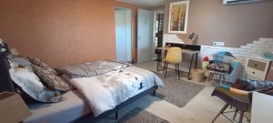 a bedroom with a bed and a table and chairs at Chambres d'Hôtes de l'Avison in Bruyères