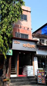 a building with a sign in front of a restaurant at Hotel Bhagirath in Mumbai