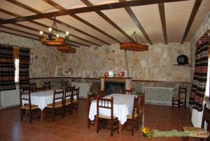 ein Esszimmer mit 2 Tischen und Stühlen sowie einem Kamin in der Unterkunft Casa Rural Dilamor in El Picazo