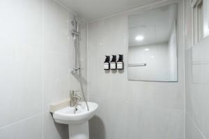a white bathroom with a sink and a toilet at stay105행궁 in Suwon +26 photos