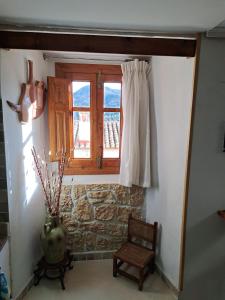 a room with a window and a chair and a vase at Casa del Convento I- Apartamento rural - in Montán +22 photos
