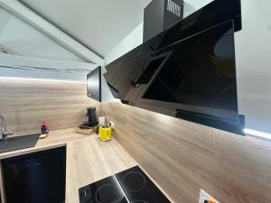 a kitchen with a stove and a large screen tv at LeLafayette in Metz