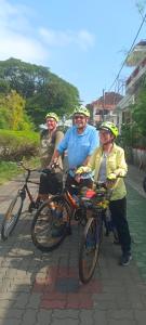 コーチにあるThe Cave houseの路上でヘルメットをかぶって自転車に乗る3人