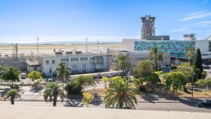 a view of an airport with palm trees and buildings at Campanile PRIME - Nice Airport in Nice