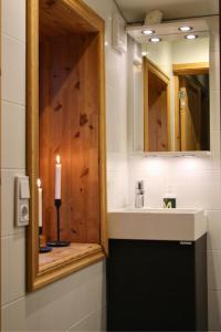 Un baño con lavabo, espejo y vela. en Cozy cabin with an amazing view, en Åre 10 fotos más