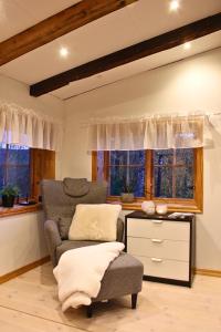 a living room with a chair and a table and windows at Cozy cabin with an amazing view in Åre +14 photos