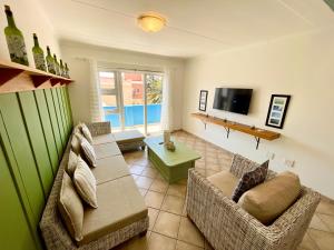 a living room with two couches and a tv at Sealavie Central Apartment in Khomas Region