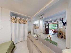 a living room with a couch and a kitchen at Anoli Studio Location in Les Trois-Îlets