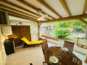 an outdoor living room with a table and chairs and a patio at Anoli Studio Location in Les Trois-Îlets +10 photos