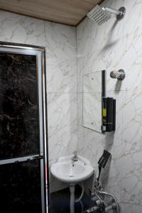 a bathroom with a sink and a mirror at Hotel Bhagirath in Mumbai