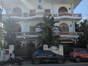 a black car parked in front of a building at The Cave house hostel in Cochin