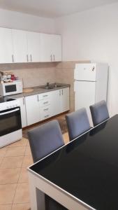 una cocina con una mesa y dos sillas azules en Apartman Miletic, en Mostar
