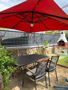 a table and chairs under a red umbrella at Apartments in Skrbcici - Insel Krk 51200 in Skrbčići