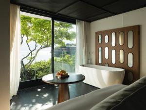 a bedroom with a tub and a table in front of a window at Dali Lanting Seaview Hotel in Dali