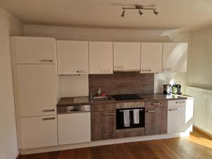 a kitchen with white cabinets and a sink at Ferienwohnung Lackner in Niedernsill