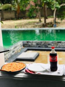 a table with a bottle of coke and a pizza at Casa Del Ceylon in Hikkaduwa