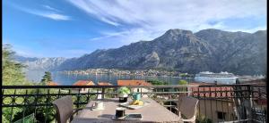 einen Tisch auf einem Balkon mit Blick auf ein Kreuzfahrtschiff in der Unterkunft Apartment Vujosevic D&D in Kotor