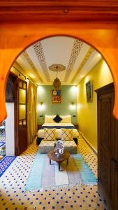 マラケシュにあるRiad Touhfa Kasbah Marrakechの部屋にベッドとテーブルがある寝室