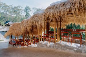 a straw hut with tables and chairs under it at Auraya Ella in Ella