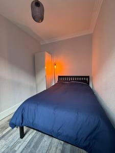 a bedroom with a bed with a blue comforter at Serenity LTD in Leicester +8 photos