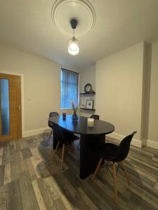 a dining room with a black table and chairs at Serenity LTD in Leicester