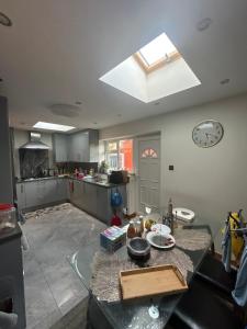 een keuken met een tafel en een klok op het plafond bij Private Room & shower- Near Central Manchester in Manchester +2 foto's