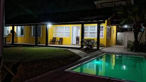 a house with a swimming pool at night at Casa 4 quartos, 2 suítes, piscina e acessibilidade - Frente para a lagoa in São Pedro da Aldeia