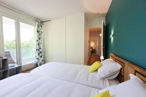 una camera da letto con due letti e una finestra di L'Hermitage lake view a Talloires