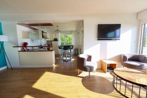 un soggiorno con tavolo e sedie e una cucina di L'Hermitage lake view a Talloires