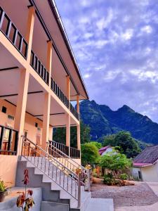 un edificio con escaleras y montañas en el fondo en phoulisack2 guesthouse, en Nongkhiaw