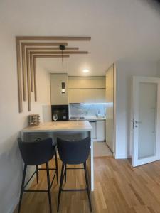 eine Küche mit 2 Stühlen und eine Insel in einem Zimmer in der Unterkunft Alex 2210 in Podgorica + 7 Fotos