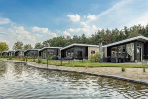 een rij modulaire woningen naast een waterlichaam bij Hillenaar in Huppel