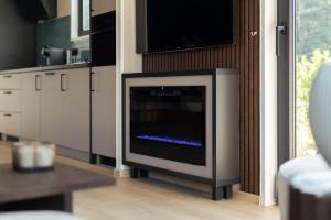een open haard in een keuken met een tv aan de muur bij Hillenaar in Huppel +6 foto's