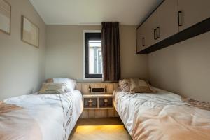 een slaapkamer met twee bedden en een raam bij Hillenaar in Huppel
