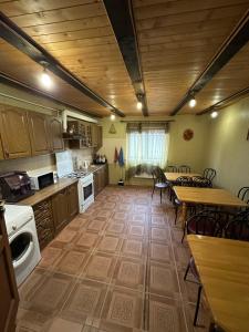 a large kitchen with a table and chairs and a table and a kitchen with at Бойківчанка in Yaremche