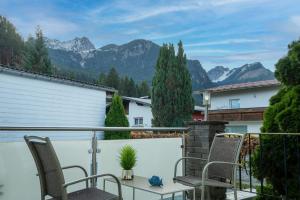 a balcony with chairs and a table and mountains at Ferienhaus Gehrenblick in Oberletzen