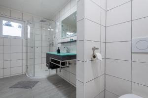 a white bathroom with a sink and a toilet at Ferienhaus Gehrenblick in Oberletzen +6 photos