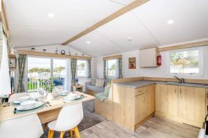 a kitchen and living room with a table and chairs at 3Bed Caravan - Muirfield in Port Seton