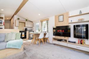 a living room with a large television and a kitchen at 3Bed Caravan - Muirfield in Port Seton +19 photos