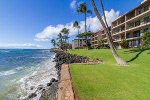 a resort with palm trees and the ocean at Lauloa 303 in Maalaea