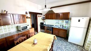 a kitchen with a table and a white refrigerator at B&E Casa Vacanze in Taranto