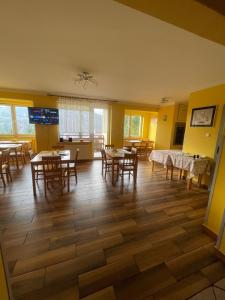 a dining room with tables and chairs and windows at Dom Wiślańskie Wzgórze in Wisła