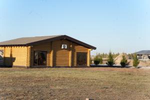 a log cabin with a large yard at Дом из сруба in Koshi +3 photos