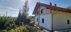 a white house with a car parked next to it at Time Out Moments Haus mit eigener Sauna in Grafenau