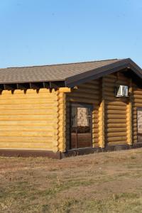 a log cabin with a window and a roof at Дом из сруба in Koshi