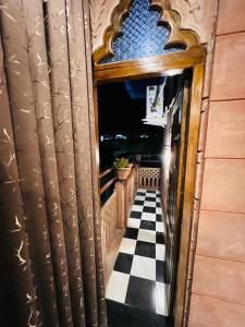 an open door to a balcony with a checkerboard floor at The Raj Heritage in Jodhpur