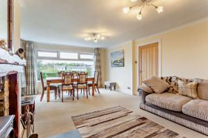 a living room with a couch and a table and chairs at Hillside in Kyleakin