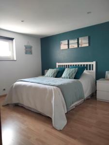 a bedroom with a large bed with blue walls at La Goélette in Bazincourt-sur-Saulx