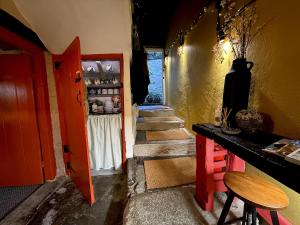 ein Zimmer mit Treppe, roter Tür und einem Tisch in der Unterkunft Charming two-bedroom apartment, One Drake Road, Tavistock in Tavistock