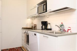 a kitchen with white cabinets and a sink at Arctic Willamo Studio- Rovaniemi in Rovaniemi